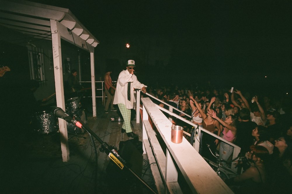 Performer on a rooftop above a crowd at night